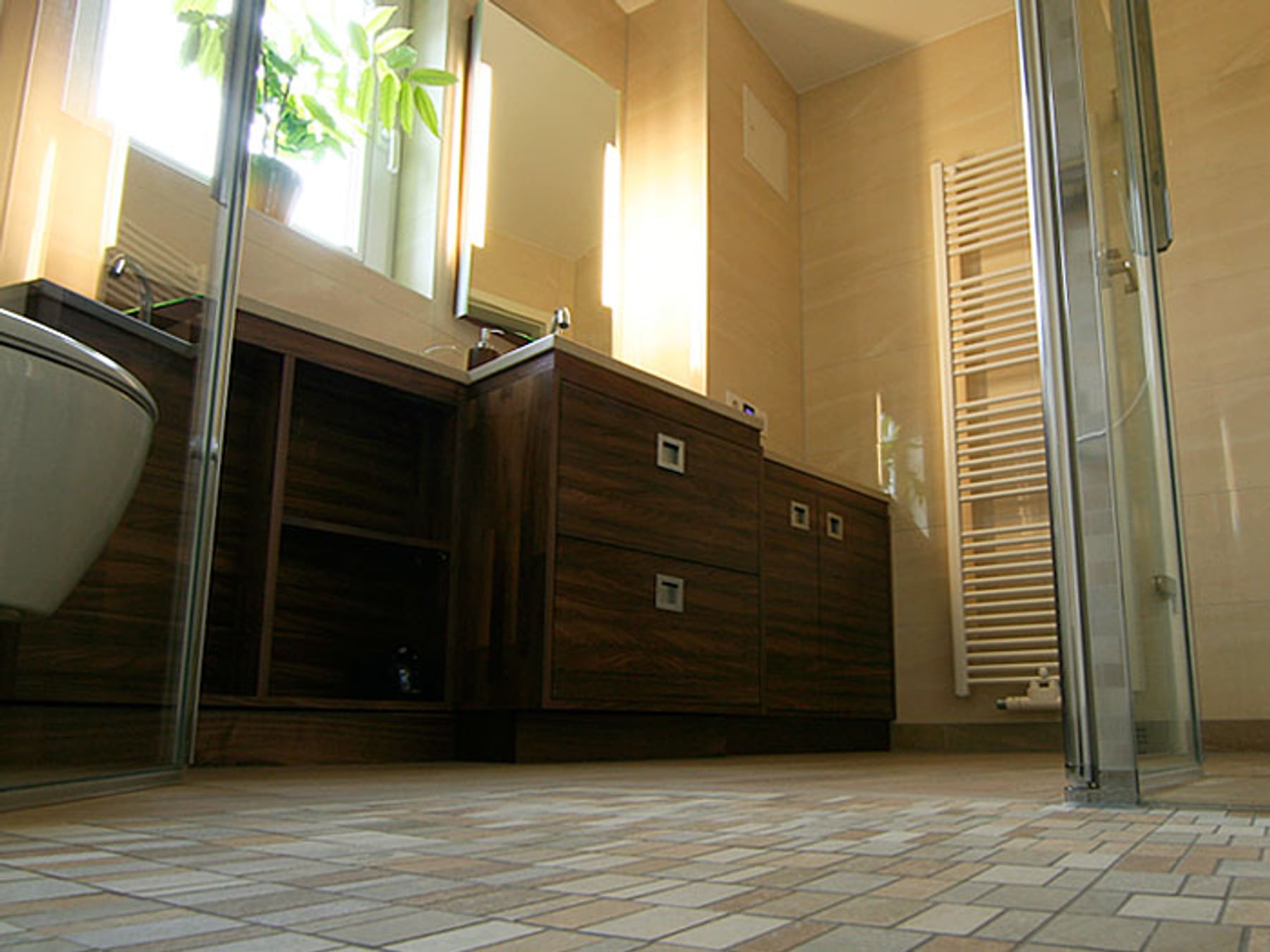 Barrierefreies Badezimmer mit holzfarbenem Waschtisch und Bodenfliesen
